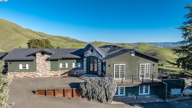 view of front of home featuring a patio, a mountain view, and french doors