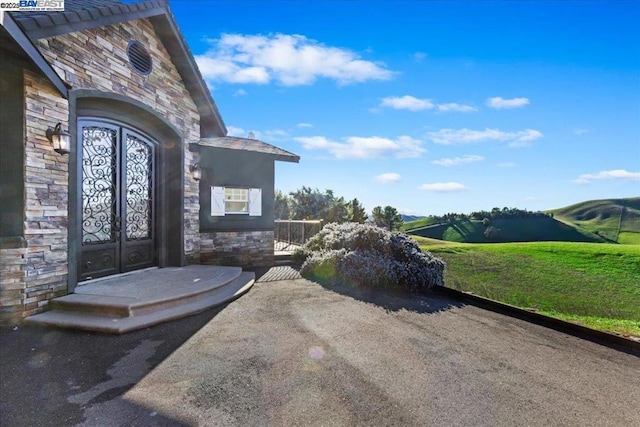 entrance to property with a lawn and french doors