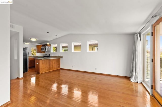 unfurnished living room featuring vaulted ceiling and light hardwood / wood-style floors