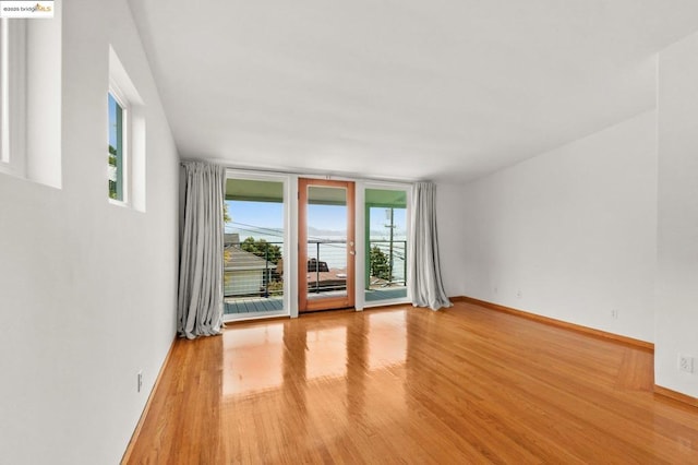 spare room featuring light hardwood / wood-style flooring and a water view