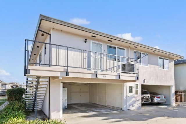 back of house with a garage and a balcony