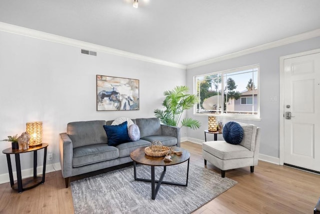 living room with ornamental molding and light wood-type flooring