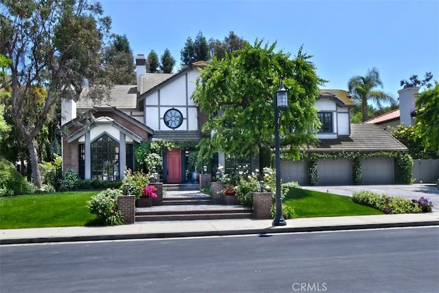 20514 Chatsboro Dr, Woodland Hills, CA 91364 - english style home featuring an attached garage, concrete driveway, a front yard, and a chimney