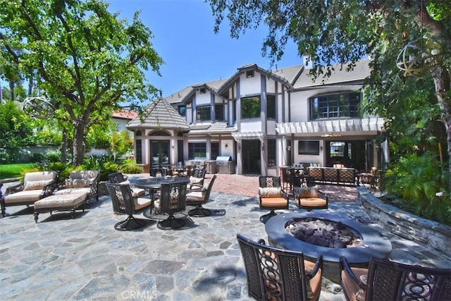 20514 Chatsboro Dr, Woodland Hills, CA 91364 - back of house featuring stucco siding, a patio area, outdoor dining space, a tile roof, and an outdoor living space with a fire pit
