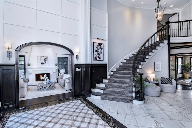 20514 Chatsboro Dr, Woodland Hills, CA 91364 - entryway featuring a high ceiling, stairs, crown molding, marble look tiles, and a lit fireplace
