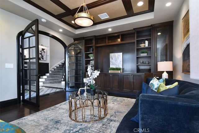 living room featuring dark hardwood / wood-style floors, coffered ceiling, and built in features