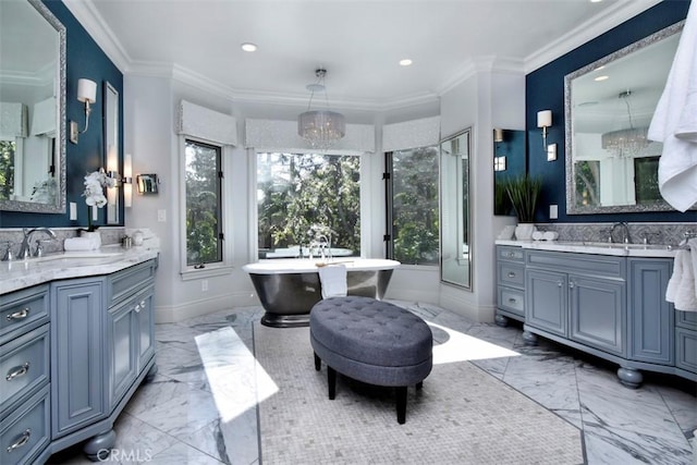 bathroom with crown molding, vanity, a bathing tub, and a chandelier