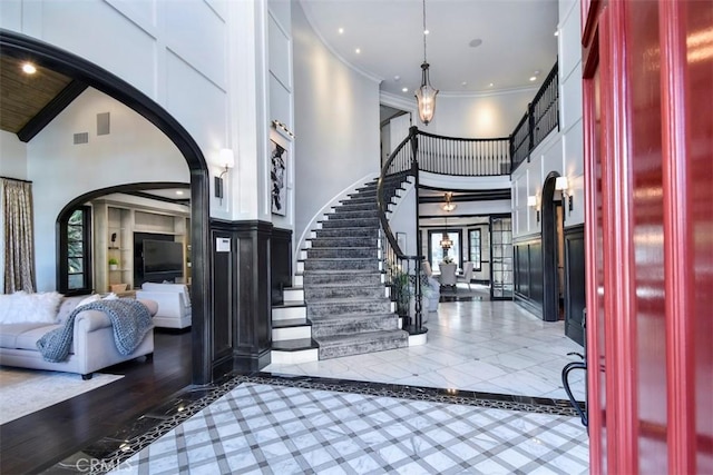 foyer entrance featuring crown molding and a high ceiling