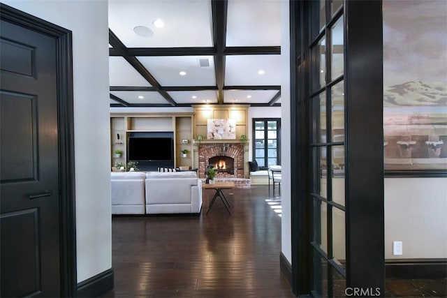 interior space with dark wood-type flooring, coffered ceiling, built in features, and beamed ceiling