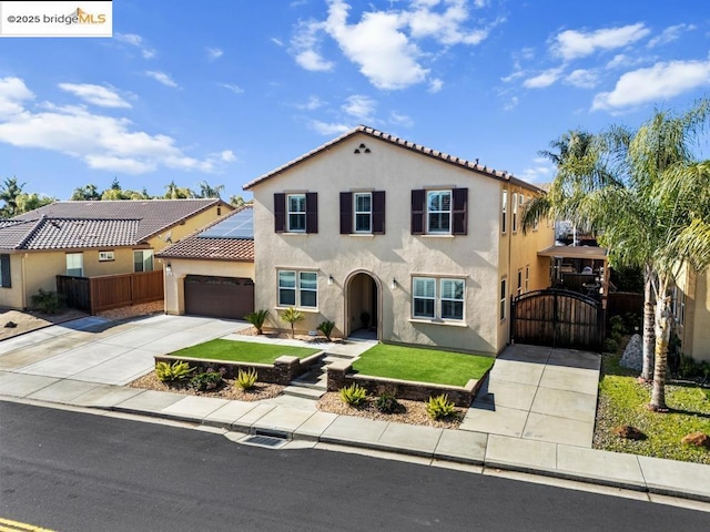 mediterranean / spanish-style home with a front lawn and solar panels