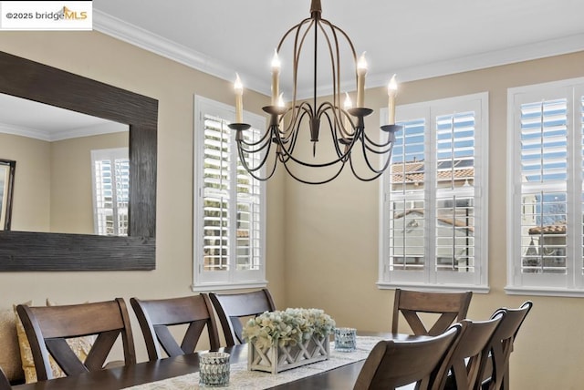 dining room with ornamental molding and a notable chandelier