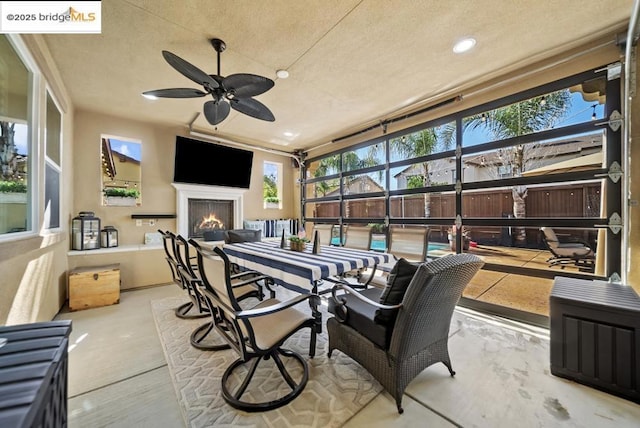 sunroom / solarium featuring ceiling fan and a healthy amount of sunlight