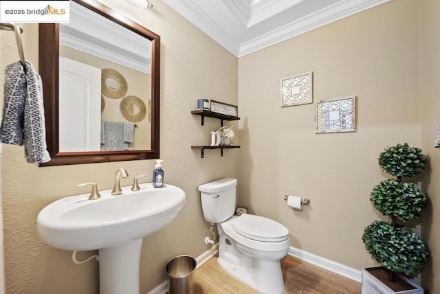 bathroom with hardwood / wood-style flooring, ornamental molding, and toilet