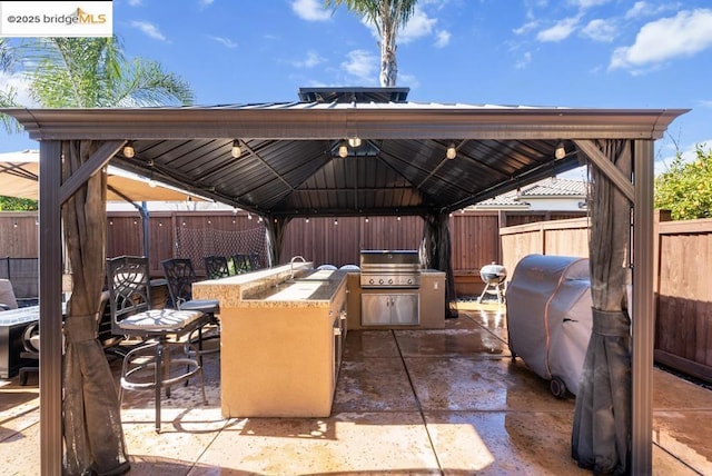 view of patio / terrace with a gazebo, area for grilling, grilling area, and a wet bar