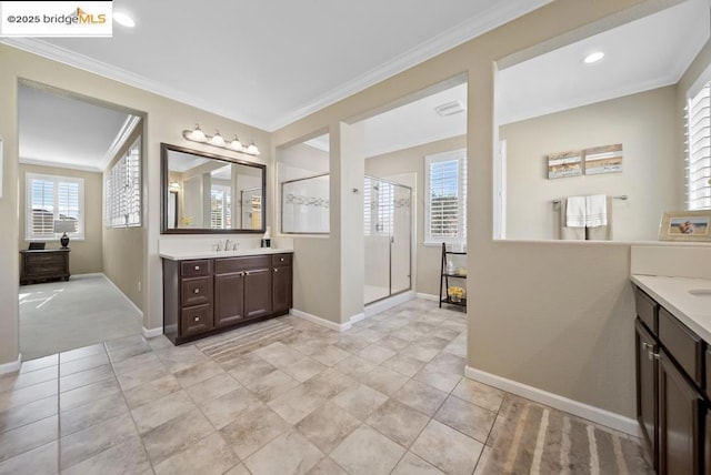 bathroom featuring vanity, crown molding, a wealth of natural light, and a shower with door