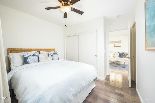 bedroom with ceiling fan, dark hardwood / wood-style floors, and a closet