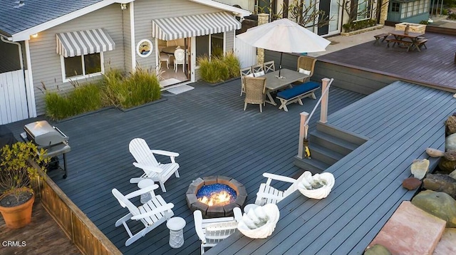 deck with area for grilling and a fire pit