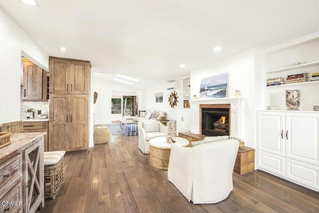 living room featuring dark wood-type flooring, built in features, and a wall mounted AC