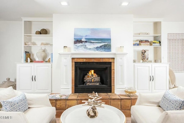 living area featuring built in shelves and a fireplace