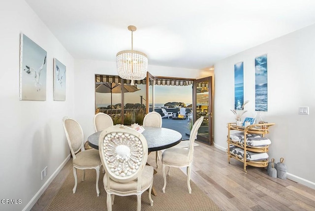 dining area with hardwood / wood-style flooring and a notable chandelier