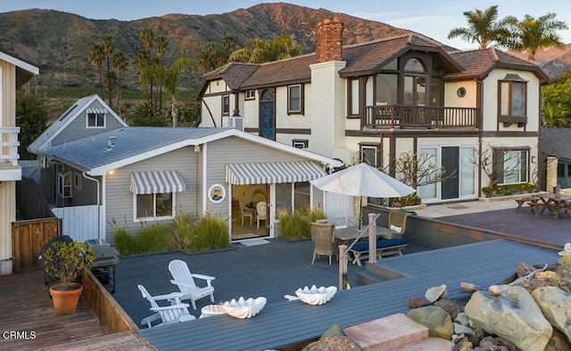 back of house featuring a balcony and a deck with mountain view