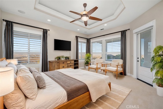 carpeted bedroom featuring a tray ceiling, access to outside, and ceiling fan