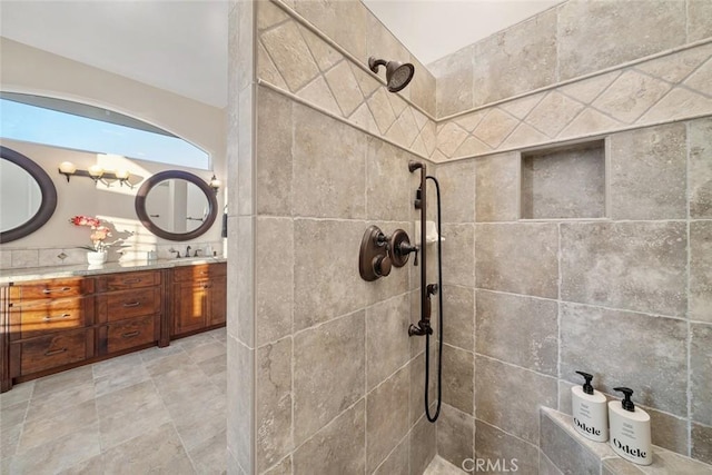 bathroom featuring tiled shower and vanity