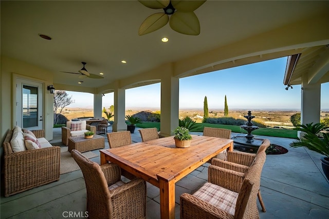 view of patio with outdoor dining area, ceiling fan, and an outdoor living space