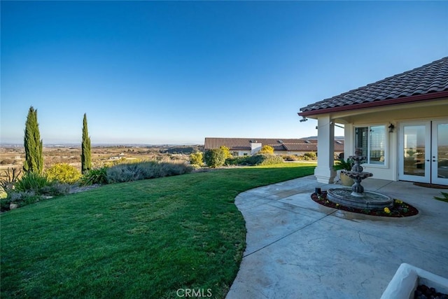 view of yard with french doors and a patio