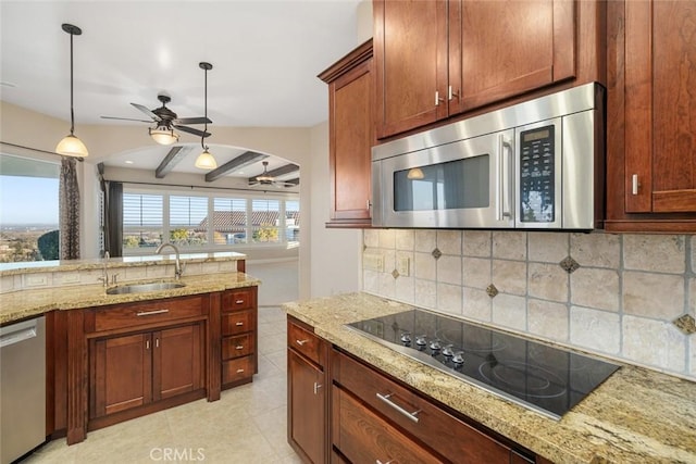 kitchen featuring ceiling fan, appliances with stainless steel finishes, light stone countertops, and hanging light fixtures