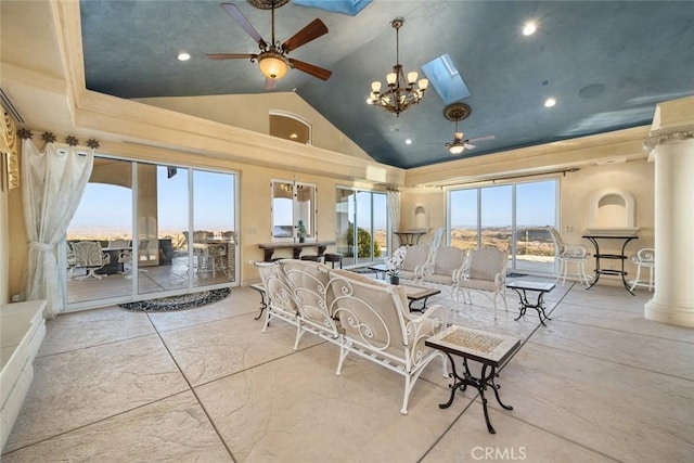 living room with a skylight, decorative columns, recessed lighting, a ceiling fan, and high vaulted ceiling
