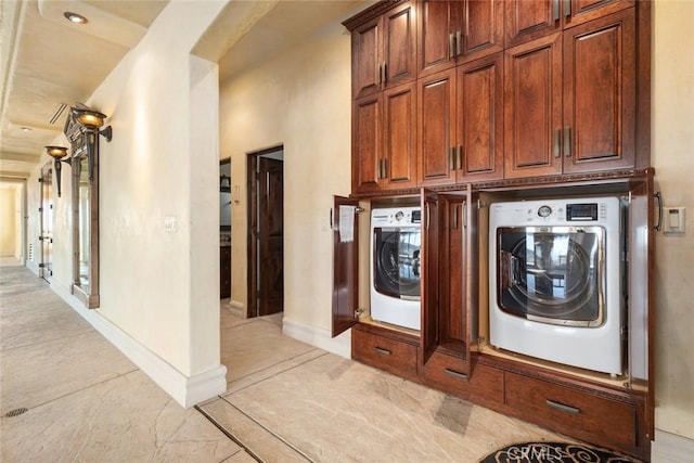 laundry room with washer / dryer and cabinets