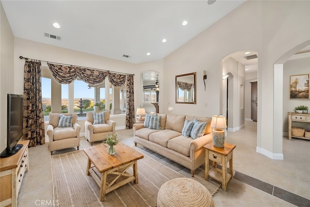 tiled living room featuring a high ceiling