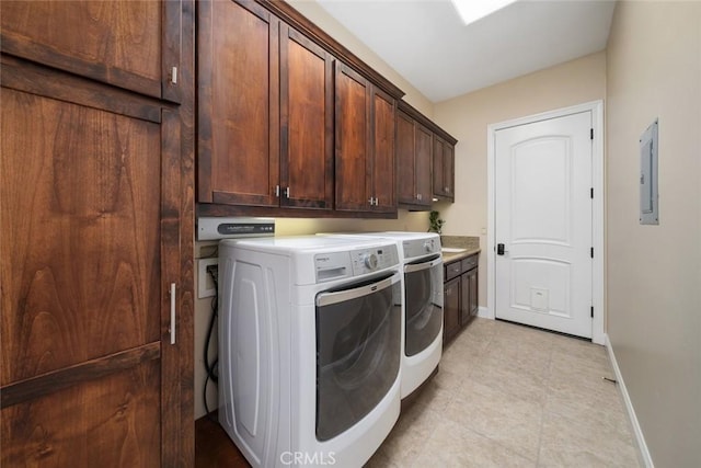 washroom with cabinets, washer and dryer, and electric panel