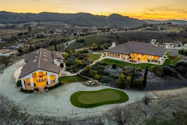 aerial view at dusk featuring a mountain view