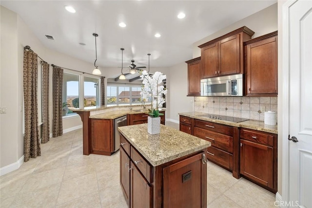 kitchen featuring light stone counters, a center island, tasteful backsplash, recessed lighting, and appliances with stainless steel finishes