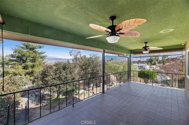 view of patio with ceiling fan and a balcony