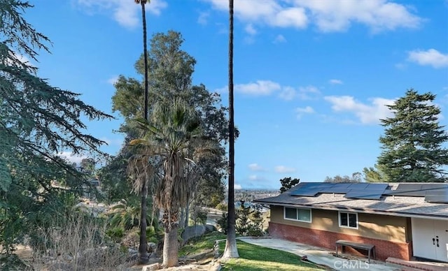 view of property exterior with a patio and solar panels