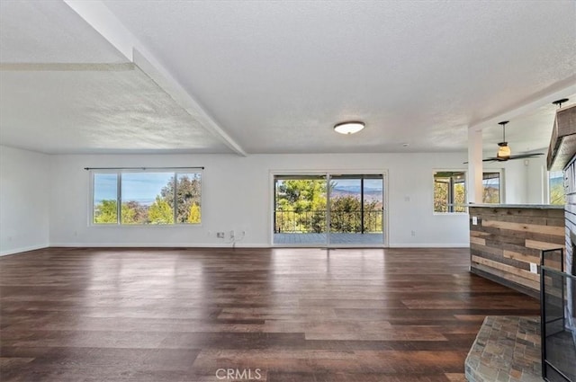 unfurnished living room with dark wood-type flooring and plenty of natural light