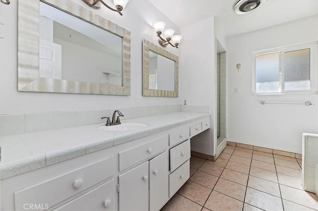 bathroom featuring tile patterned flooring, vanity, and walk in shower