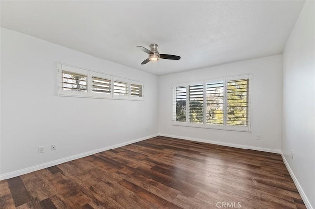 spare room with ceiling fan, a healthy amount of sunlight, and dark hardwood / wood-style flooring