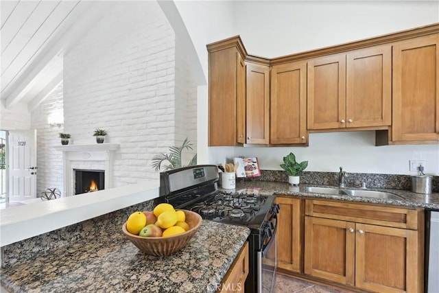 kitchen featuring dark stone countertops, sink, vaulted ceiling with beams, and appliances with stainless steel finishes