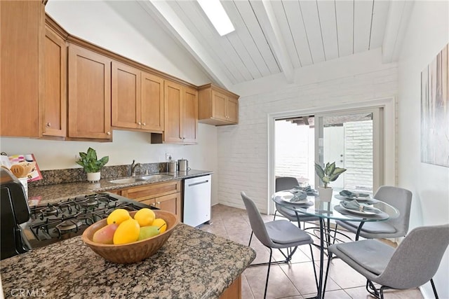 kitchen featuring sink, light tile patterned floors, dishwasher, dark stone countertops, and vaulted ceiling with beams