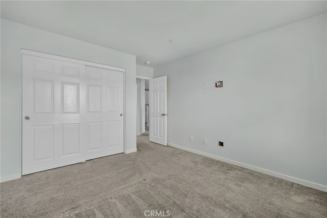 unfurnished bedroom with a closet and light carpet