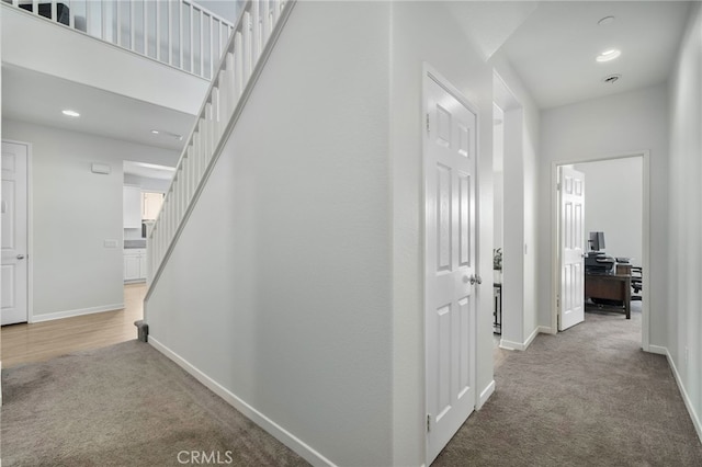 hallway featuring carpet flooring and a high ceiling