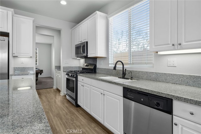 kitchen with white cabinetry, stainless steel appliances, and sink