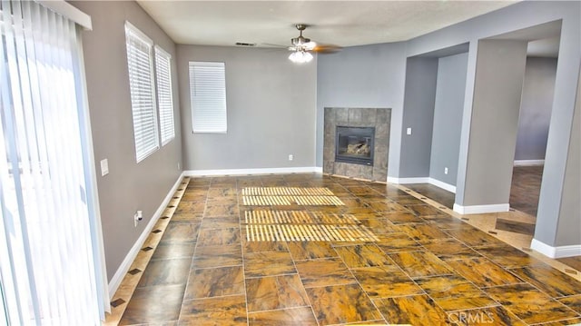 unfurnished living room featuring ceiling fan and a fireplace