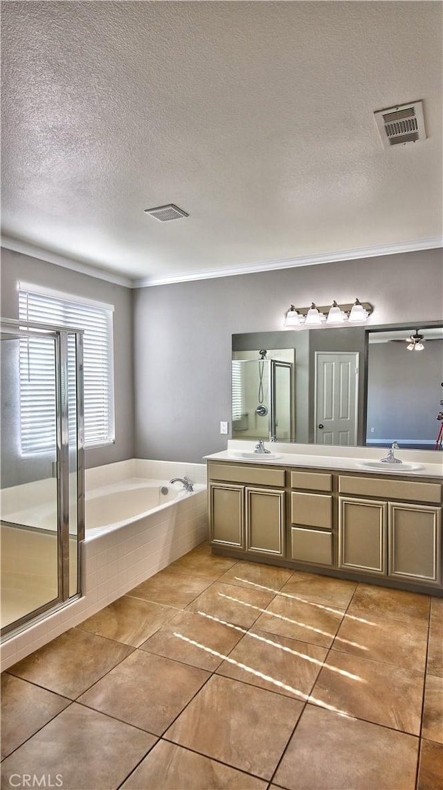 bathroom with vanity, tile patterned floors, plus walk in shower, and a textured ceiling