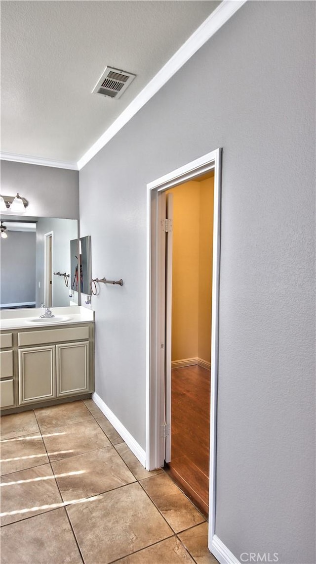 bathroom with vanity, crown molding, and tile patterned floors