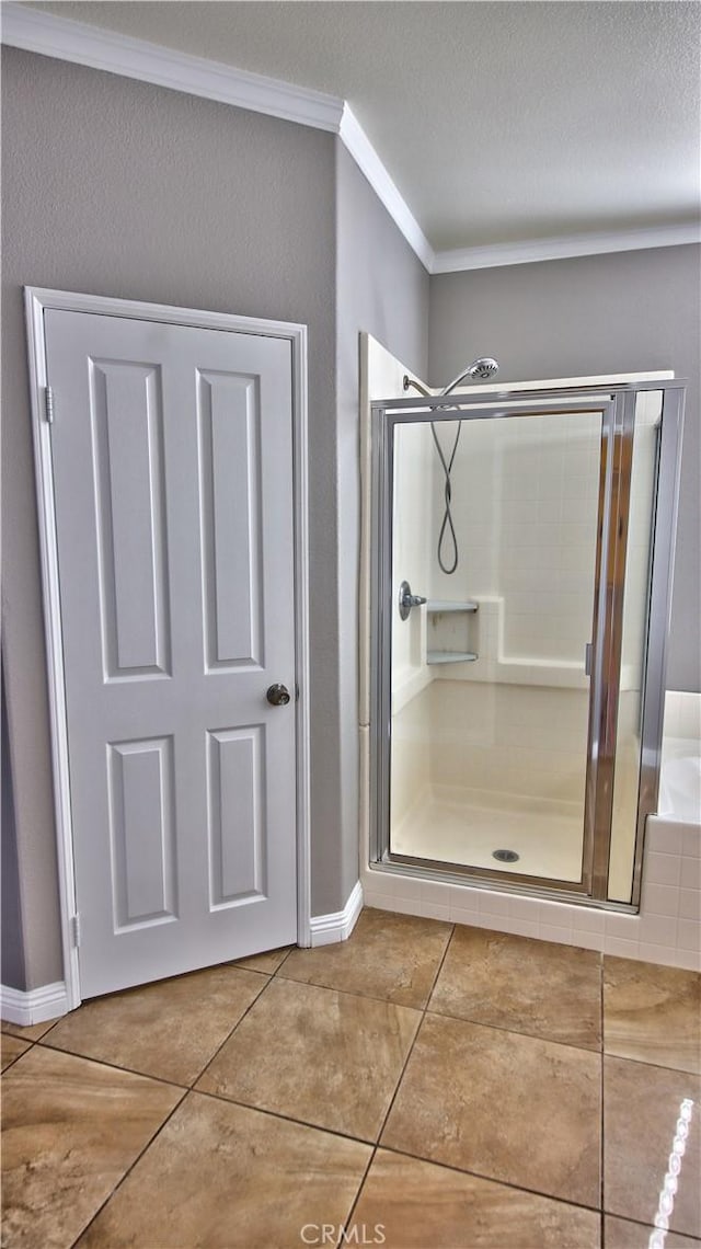 bathroom featuring tile patterned flooring, crown molding, a shower with door, and a textured ceiling